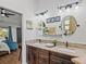 Bathroom with double sinks, granite countertops, dark wood cabinets, and decorative art at 7508 W Short Rd, Plant City, FL 33565