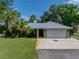 Home exterior features a metal roof, a well-maintained lawn, and mature landscaping at 7508 W Short Rd, Plant City, FL 33565