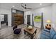 Inviting living room with hardwood floors, accent wall, and a modern ceiling fan at 7508 W Short Rd, Plant City, FL 33565