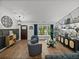 Inviting living room with wood-look floors, stylish decor, and ample natural light from the large window at 7508 W Short Rd, Plant City, FL 33565