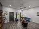 An open floor plan living area with gray plank flooring and a modern ceiling fan at 7508 W Short Rd, Plant City, FL 33565