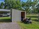 A utility shed next to a lawn mower on a grassy lawn at 7508 W Short Rd, Plant City, FL 33565
