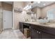 Bathroom with double vessel sinks, granite countertop, and neutral-colored tiled floors at 7615 S Fitzgerald St, Tampa, FL 33616