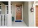 Close up view of the door with welcome flower decoration, light fixture and front porch at 7615 S Fitzgerald St, Tampa, FL 33616