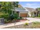 Street view of home highlighting a 2-car garage, palm trees, and verdant landscaping at 7615 S Fitzgerald St, Tampa, FL 33616