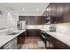 Open kitchen with stainless steel appliances, granite countertops, tile backsplash, and dark wood cabinetry at 7615 S Fitzgerald St, Tampa, FL 33616