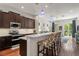 The open kitchen features a bar with stools, dark cabinets and stainless steel appliances at 7615 S Fitzgerald St, Tampa, FL 33616