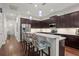 Bright open kitchen featuring stainless steel appliances, granite countertops, tile backsplash, and dark wood cabinetry at 7615 S Fitzgerald St, Tampa, FL 33616