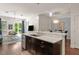 Bright kitchen featuring stainless steel appliances, granite countertops, dark wood cabinets, and island with sink at 7615 S Fitzgerald St, Tampa, FL 33616