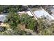 Aerial view of a beautiful home with a brick driveway, mature trees, and a screened-in pool at 8238 30Th N Ave, St Petersburg, FL 33710