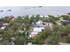 An aerial view shows a home with a pool amid lush trees, near the bay, showcasing the neighborhood at 8238 30Th N Ave, St Petersburg, FL 33710