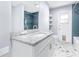 A bathroom features an updated vanity, shower with blue tiling, and new tile floors at 8238 30Th N Ave, St Petersburg, FL 33710