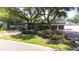 Home with a beautiful lawn, mature trees, and brick driveway leading to the attached garage at 8238 30Th N Ave, St Petersburg, FL 33710