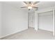 Bright bedroom featuring plush carpeting, ceiling fan, and convenient access to a closet at 8598 Parsons Hill Blvd, Wesley Chapel, FL 33545