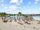 Expansive community lagoon with sandy beach, lounge chairs, umbrellas, and clear blue water for leisure and recreation at 8598 Parsons Hill Blvd, Wesley Chapel, FL 33545