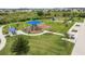 Aerial view of a community park with a playground, picnic areas, and lush green space for outdoor activities at 8598 Parsons Hill Blvd, Wesley Chapel, FL 33545
