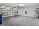 Spacious garage with a metal door, water heater, and plenty of room for vehicles and storage at 8598 Parsons Hill Blvd, Wesley Chapel, FL 33545
