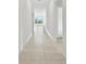 Bright hallway featuring tile flooring leading to a sunlit living area, creating an open and inviting atmosphere at 8598 Parsons Hill Blvd, Wesley Chapel, FL 33545