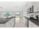 Modern kitchen with stainless steel appliances, granite countertops, and white cabinetry offering an elegant cooking space at 8598 Parsons Hill Blvd, Wesley Chapel, FL 33545