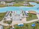 Aerial view of community lagoon amenities including beach area, bar, seating, and clear blue water for recreation at 8598 Parsons Hill Blvd, Wesley Chapel, FL 33545