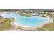 A large, clear lagoon with a sandy beach area surrounded by recreational facilities at 8598 Parsons Hill Blvd, Wesley Chapel, FL 33545