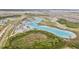 A lagoon surrounded by houses, recreational facilities, and lush green landscaping at 8598 Parsons Hill Blvd, Wesley Chapel, FL 33545