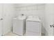 A well-lit laundry room featuring a washer, dryer, and overhead wire shelving at 8598 Parsons Hill Blvd, Wesley Chapel, FL 33545