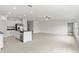 Open-concept living space with tile flooring, a ceiling fan, and a kitchen featuring an island with granite countertops at 8598 Parsons Hill Blvd, Wesley Chapel, FL 33545