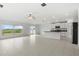 Bright and airy living room featuring tile floors, a ceiling fan, and sliding glass doors leading to the backyard at 8598 Parsons Hill Blvd, Wesley Chapel, FL 33545