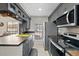 Well-lit kitchen featuring gray cabinets, stainless steel appliances, and dark countertops at 8724 Mallard Reserve Dr # 101, Tampa, FL 33614