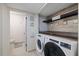 Efficient laundry room with modern washer, dryer, and built-in storage shelves for organized living at 8724 Mallard Reserve Dr # 101, Tampa, FL 33614