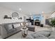 Inviting living room features a comfortable gray sectional sofa, fireplace, and a decorative round mirror at 8724 Mallard Reserve Dr # 101, Tampa, FL 33614