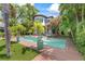 Spacious backyard oasis featuring a sparkling pool, lush landscaping, and a serene waterfront setting at 90 Bahama Cir, Tampa, FL 33606