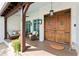 Inviting front porch with stylish furniture, double wood doors, and exterior lighting at 90 Bahama Cir, Tampa, FL 33606