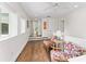 Bright hallway sitting area features hardwood floors, windows for natural light, and colorful, decorative accent chairs at 90 Bahama Cir, Tampa, FL 33606