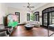 Bright living room with a ceiling fan, dark wood floors, sofa, decorative armoire, and black framed windows at 90 Bahama Cir, Tampa, FL 33606