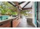 This outdoor kitchen features a built-in grill, wood cabinets, and a beautiful view of the pool and waterway at 90 Bahama Cir, Tampa, FL 33606