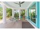 Covered patio has white columns, comfortable seating, and a door offering a seamless indoor-outdoor living experience at 90 Bahama Cir, Tampa, FL 33606
