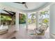 Covered patio has white columns, decorative seating, and overlooks the tranquil pool and waterfront views at 90 Bahama Cir, Tampa, FL 33606