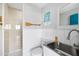 Nautical themed bathroom with shower, stainless steel sink, white wainscoting, and paddle decoration at 9048 Wharf Ave, Placida, FL 33946