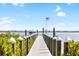 Long dock with an American flag leading to a beautiful bay with a boat underneath puffy white clouds at 9048 Wharf Ave, Placida, FL 33946