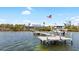 Waterfront home featuring private dock and boat lift with an American flag waving in the background at 9048 Wharf Ave, Placida, FL 33946