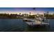 Waterfront home featuring private dock and boat lift with an American flag waving in the background at sunset at 9048 Wharf Ave, Placida, FL 33946