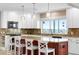Open kitchen features granite counters, white cabinets, island with bar stool seating, and views of the water at 9048 Wharf Ave, Placida, FL 33946