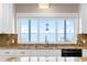Kitchen sink with window overlooking the water, granite countertops, and updated appliances at 9048 Wharf Ave, Placida, FL 33946