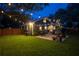 Charming backyard patio with string lights, lush lawn, and privacy fence create a cozy outdoor living space at 938 16Th N Ave, St Petersburg, FL 33704