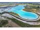 Expansive aerial view of a community lagoon with turquoise water, white sand beaches, and recreational features at 11146 Rustic Timber Loop, San Antonio, FL 33576