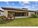 An alluring covered back patio offers seamless indoor-outdoor living with sliding glass doors and lush landscaping at 11146 Rustic Timber Loop, San Antonio, FL 33576
