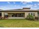A backyard featuring a covered patio, beautiful landscaping, and lush lawn at 11146 Rustic Timber Loop, San Antonio, FL 33576