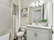 An inviting bathroom featuring a vanity with white countertop, tub with curtain, and stylish fixtures at 11146 Rustic Timber Loop, San Antonio, FL 33576